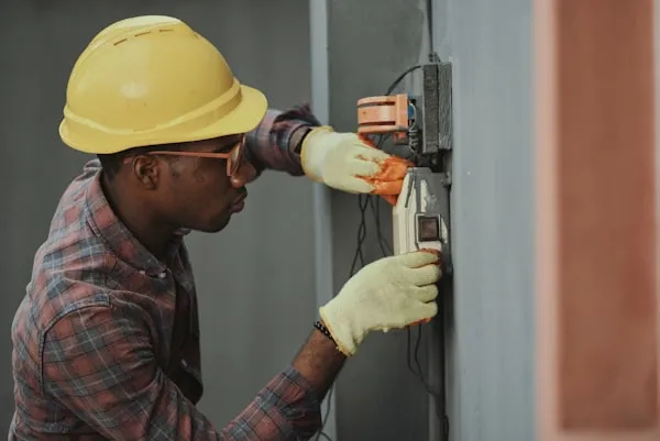 HVAC technician smiling while working on AC unit